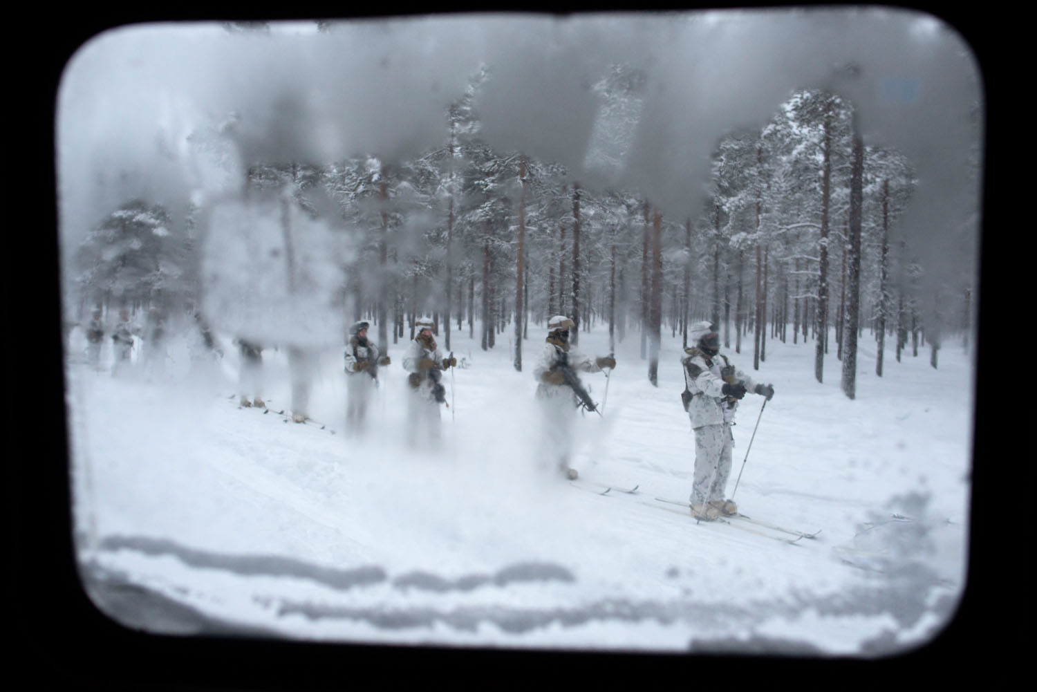 US soldiers tethered together and pulled by a Finnish tracked vehicle, a strategy used for the swift movement and repositioning of infantry. Sodankylä, Finland, February, 2023.