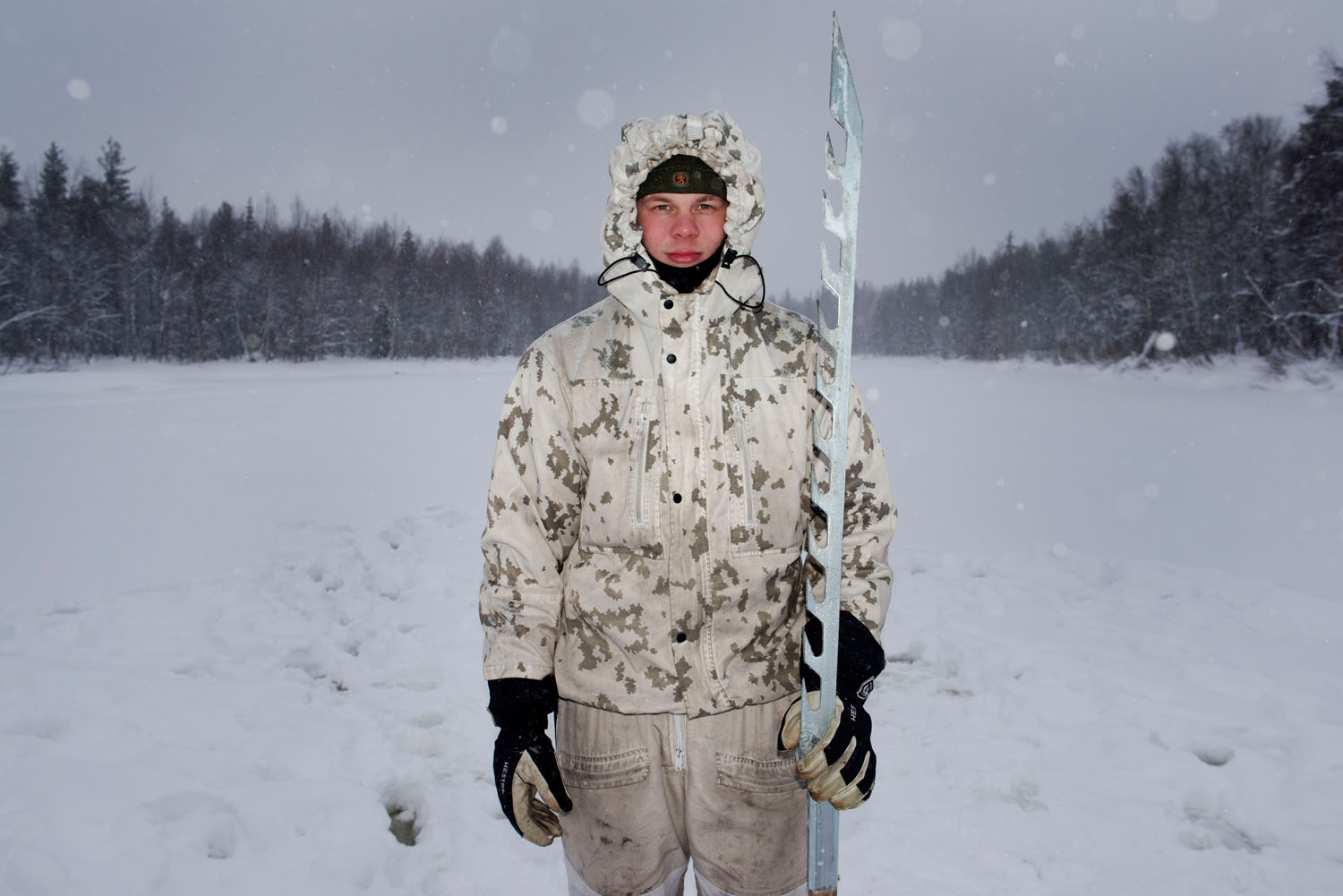 A Finnish soldier holds a special saw for testing ice thickness while training US troops for winter warfare. Sodankylä, Finland, February, 2023.