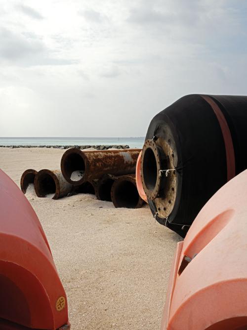Dredging pipes close-up on beach.