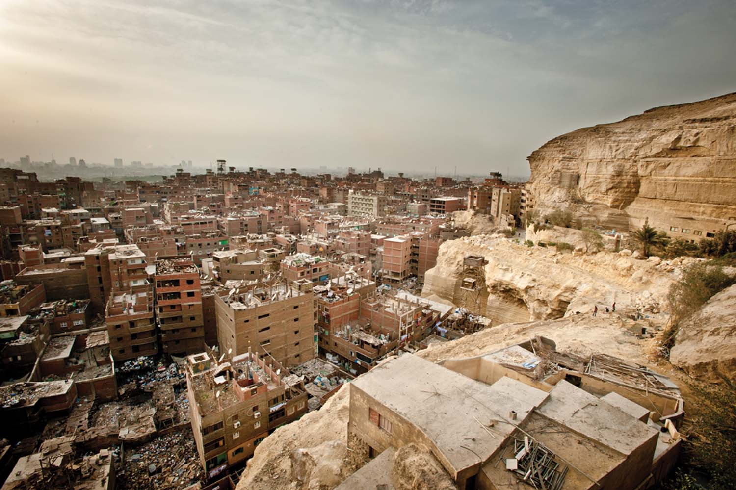 The view of Manshiet Nasser's garbage village and the Cairo skyline from the Moqattam Cliffs, the site of the Coptic Christian Cathedral of Saint Simon the Tanner.